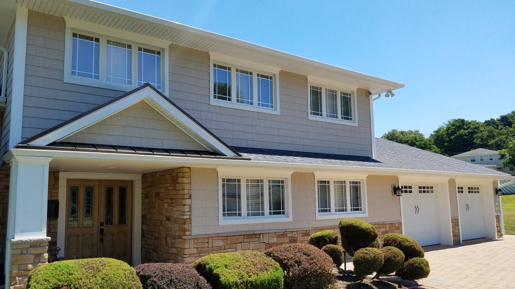 New beige vinyl siding, white trim, new grey roof and windows with prairie grids with beautiful detail installed by Roofing, Siding, Window Contractor in Morristown