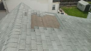 Roof area with missing shingles and could be a possible Leak entry point. Missing 3 tab shingle on a gable roof.